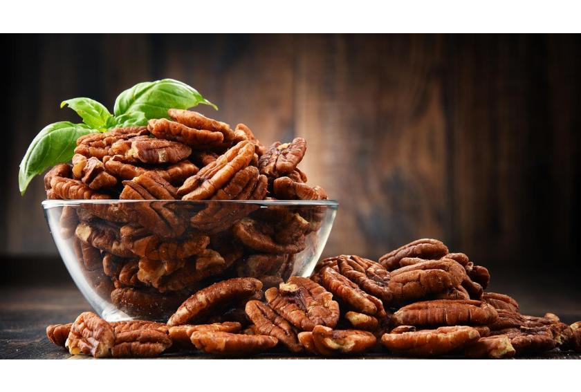 Fresh Pecans in Glass Bowl on Wooden Table Hero