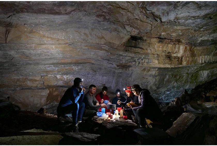 PESH Cavers gather around stone deep in cave